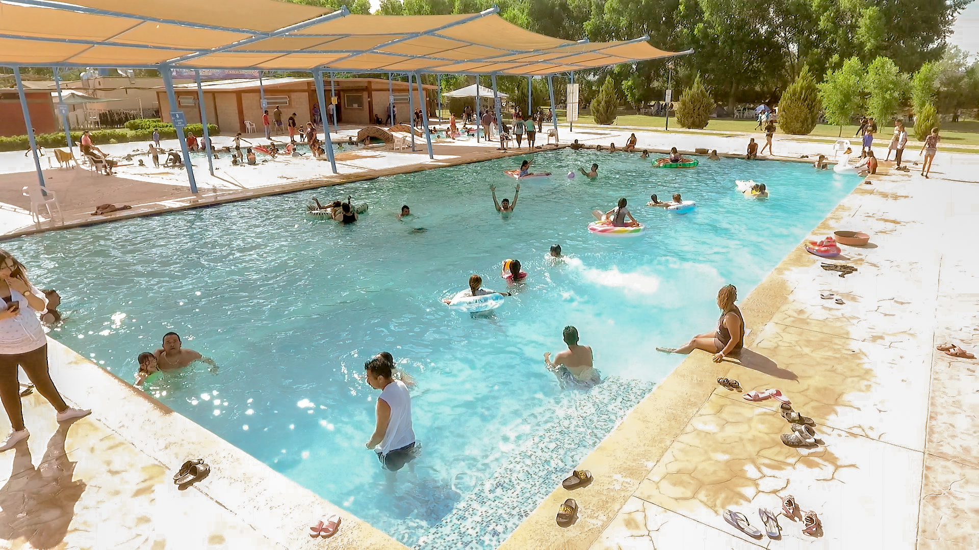 Alberca semiolímpica llena de visitantes disfrutando