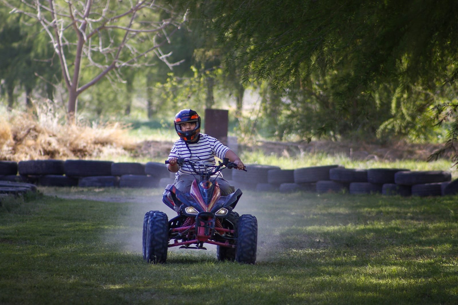 Niño manejando cuatrimoto en la pista del parque