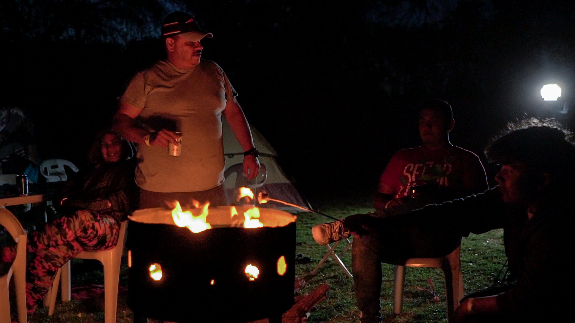 Familia disfrutando de una fogata nocturna en el camping